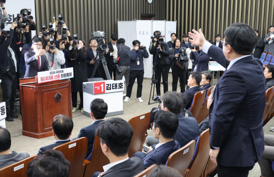 한동훈 국민의힘 대표가 지난 12일 국회에서 열린 원내대표 선출을 위한 국민의힘 의원총회에서 강명구 의원으로부터 강한 항의를 받고 있다. [연합뉴스 제공]